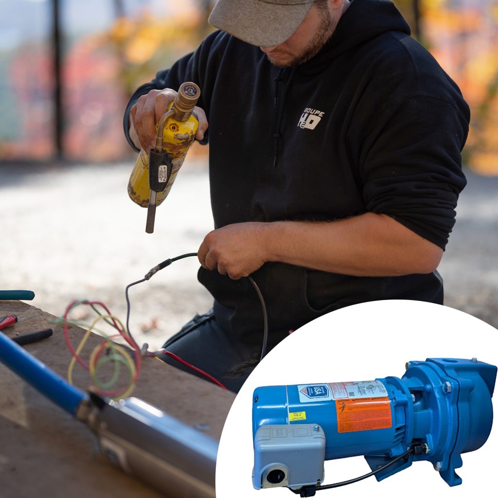Ouvrier en train d'installer une pompe pour puits avec un moteur électrique en gros plan.